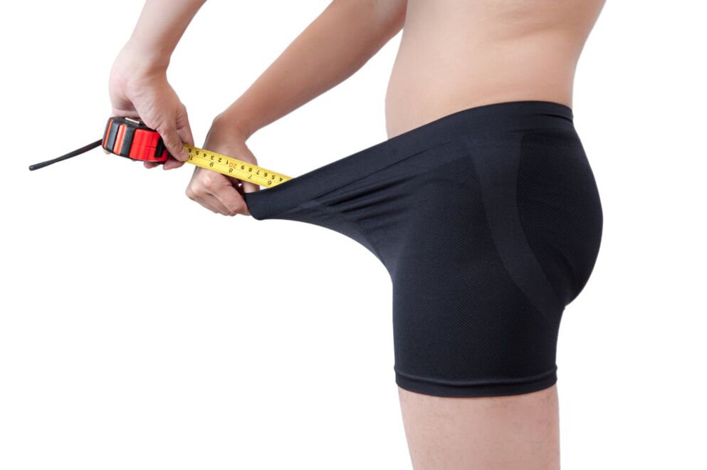 A man measures the result of penis enlargement.